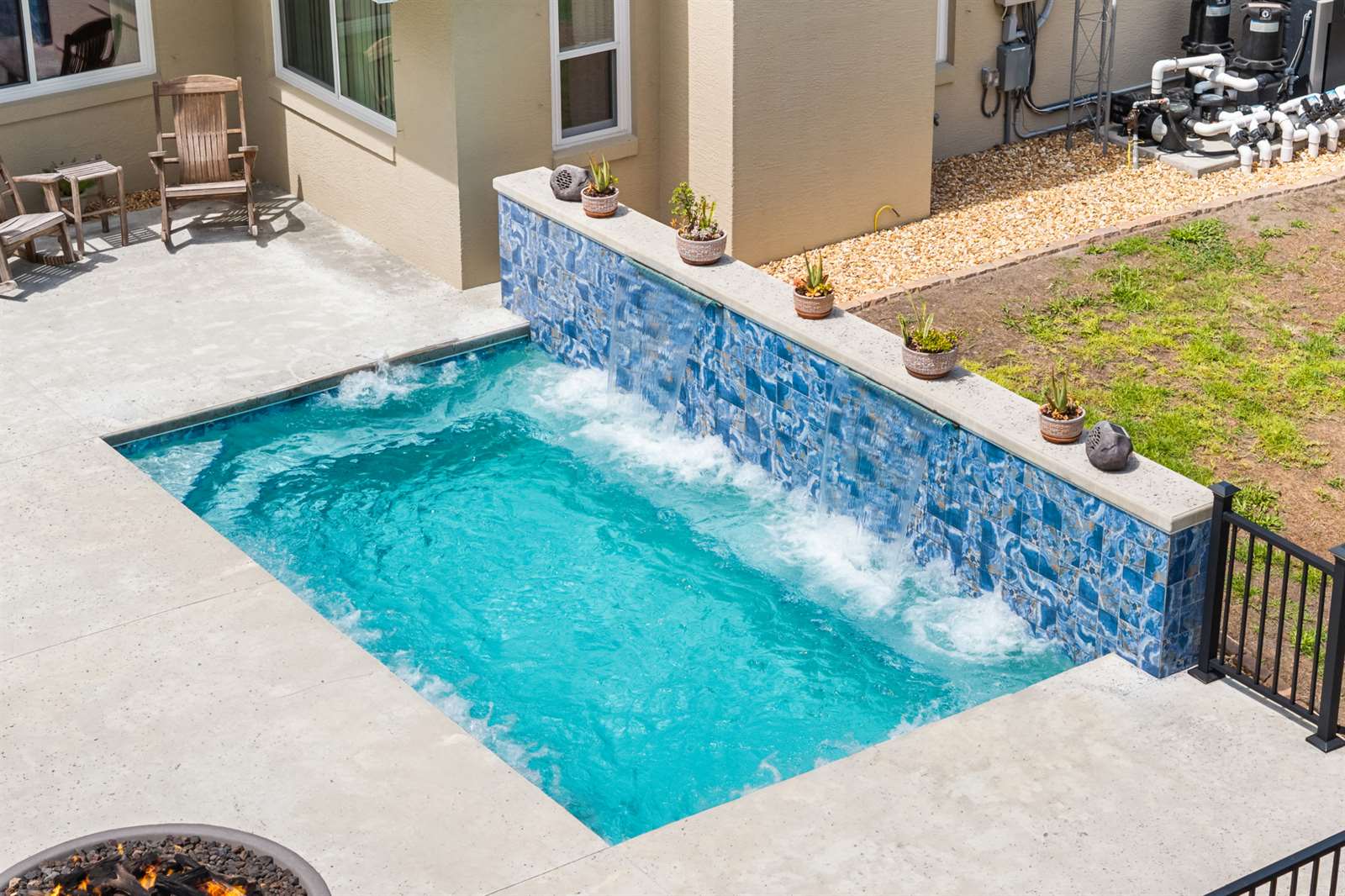 pool featuring a waterfall, surrounded by a patio area