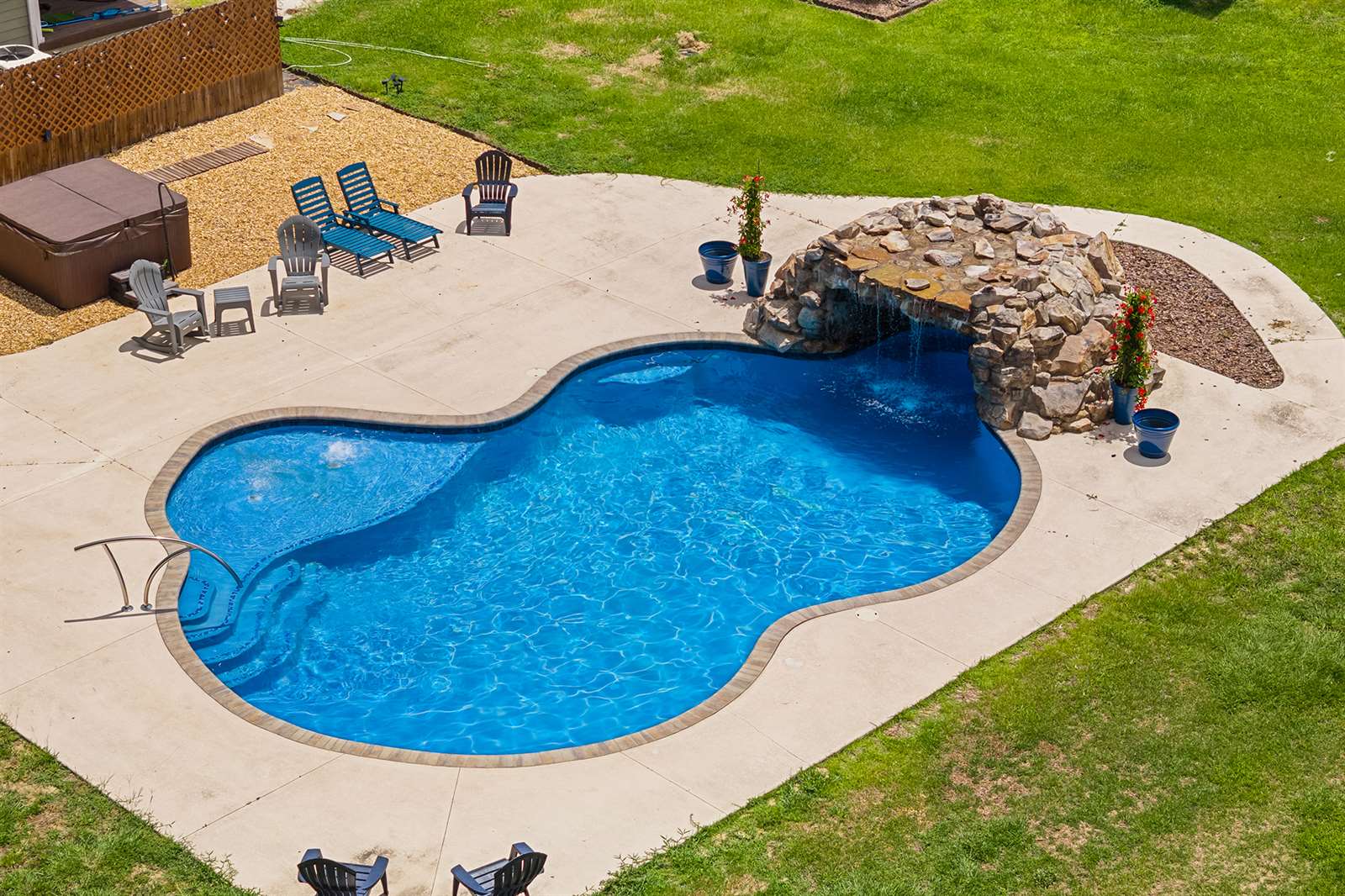 pool featuring a waterfall, surrounded by a patio area